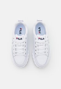 Sneakers bianchi con tomaia in pelle liscia, punta rotonda e design con lacci. Presentano una soletta azzurro chiaro e il marchio Fila in rosso e nero.