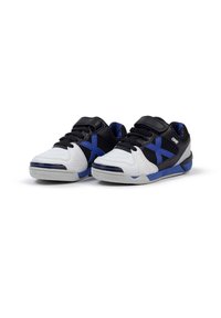 Zapatillas deportivas en blanco y negro con toques azules, que presentan una parte superior texturizada, un collar acolchado, cordones y una suela de goma gruesa.