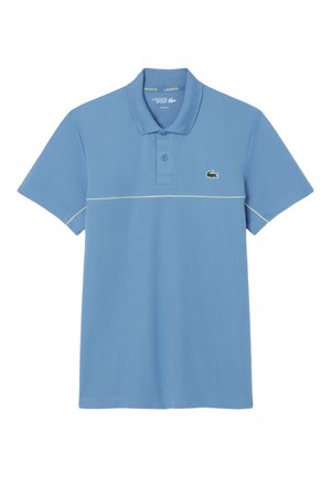 Polo de manga corta azul claro con cuello, dos botones, sutil ribete horizontal en crema y pequeño logo del cocodrilo verde de Lacoste en el pecho.