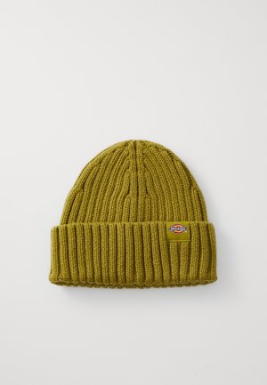Knit beanie in olive green, with a ribbed texture and a folded cuff. Features a small logo patch on the side.
