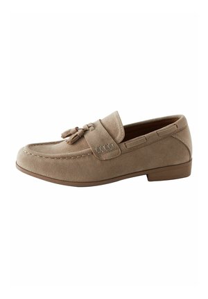 Beige suède loafer met kwastdetail, moc-toenaad en lage bruine hak, getoond vanaf de binnenzijde op een witte achtergrond.