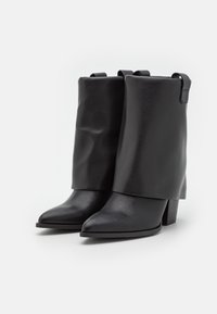 Czarne skórzane botki z szpiczastym noskiem, zagiętym dookoła i słupkowym obcasem. Gładka faktura z minimalną ilością metalowych elementów.