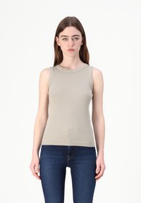 Beige bezramenný žebrovaný top s kulatým výstřihem, příjemný na dotek, přiléhavý střih, kombinovaný s tmavě modrými džíny.