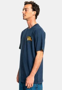 Navy cotton t-shirt with short sleeves, featuring a colorful graphic on the left chest area. Loose fit and straight hem design.