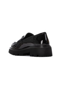 Zapatos negros de charol tipo slip-on con una suela de plataforma gruesa negra y un tacón texturizado. Presentan una puntera redondeada y un detalle de costura mínima.