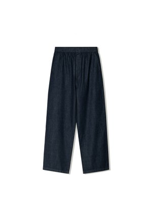 Dżinsowe spodnie typu wide-leg w ciemnym kolorze, z elastycznym paskiem, gładką fakturą, skróconą długością oraz bez widocznych kieszeni czy ozdób.
