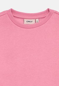 Ανοιχτό ροζ φούτερ με στρογγυλή λαιμόκοψη και ριμπ τελείωμα. Διαθέτει λείο ύφασμα και ετικέτα με το όνομα της μάρκας στο εσωτερικό του γιακά.