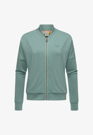Veste bomber vert clair en tissu doux. Elle présente une fermeture éclaire à l'avant, des poignets côtelés et un petit logo brodé sur la poitrine.