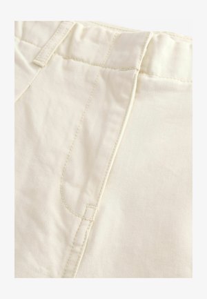 Lysebeige bomuldsbukser har en glat tekstur, diskret syning på frontlommen og et klassisk design på livet uden yderligere udsmykninger.