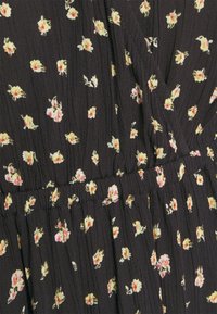 Schwarzes Stoffkleid mit kleinem Blumenmuster in Gelb und Pink. Es verfügt über Falten und einen elastischen Bund für eine formende Passform. Weiche Textur.