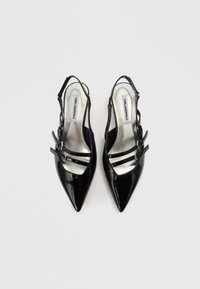 Μαύρα σατινέ δερμάτινα παπούτσια slingback με μυτερή μύτη, που διαθέτουν τρεις στενές λουρίδες και εσωτερικό με ασημένιο περίγραμμα. Περιλαμβάνεται διακοσμητική αγκράφα.