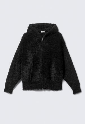 Must karvane lukuga kapuutsiga pusa pikkade varrukatega, laotatud lamedalt heledal taustal.