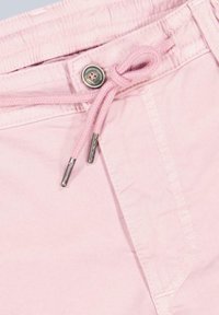 Light pink shorts featuring an elastic waistband with a drawstring, metal button closure, and visible stitching details.