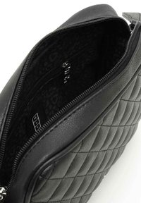 Borsa nera in ecopelle trapuntata con apertura con zip, dotata di un interno a fantasia e di una piccola tasca interna.