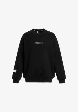 Sudadera negra hecha de tela de felpa. Presenta un escote redondo, puños acanalados y un parche rectangular con dos botones en la parte delantera.