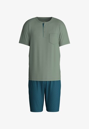 Groen katoenen shirt met korte mouwen, een zakje en een henley-halslijn. Gecombineerd met donkerblauwe shorts met een stippenpatroon voor contrast.