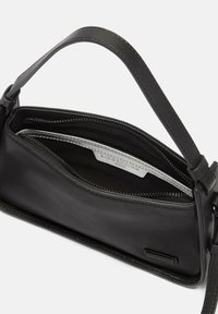 Schwarze Lederhandtasche mit geschwungener Form, Reißverschluss und kurzem Griff. Das Innere verfügt über ein silbernes Futter und ein Markenlabel.