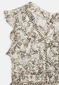 Hedvábná blůza s potiskem květinových motýlů a volánkovými rukávy, krémové pozadí, tmavé akcenty a chevronový detail podél výstřihu.