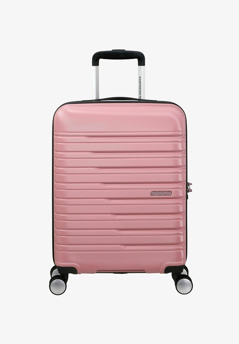 Valigia rigida rosa con linee verticali texturizzate, manico telescopico, quattro ruote e zip nera in accentuazione.