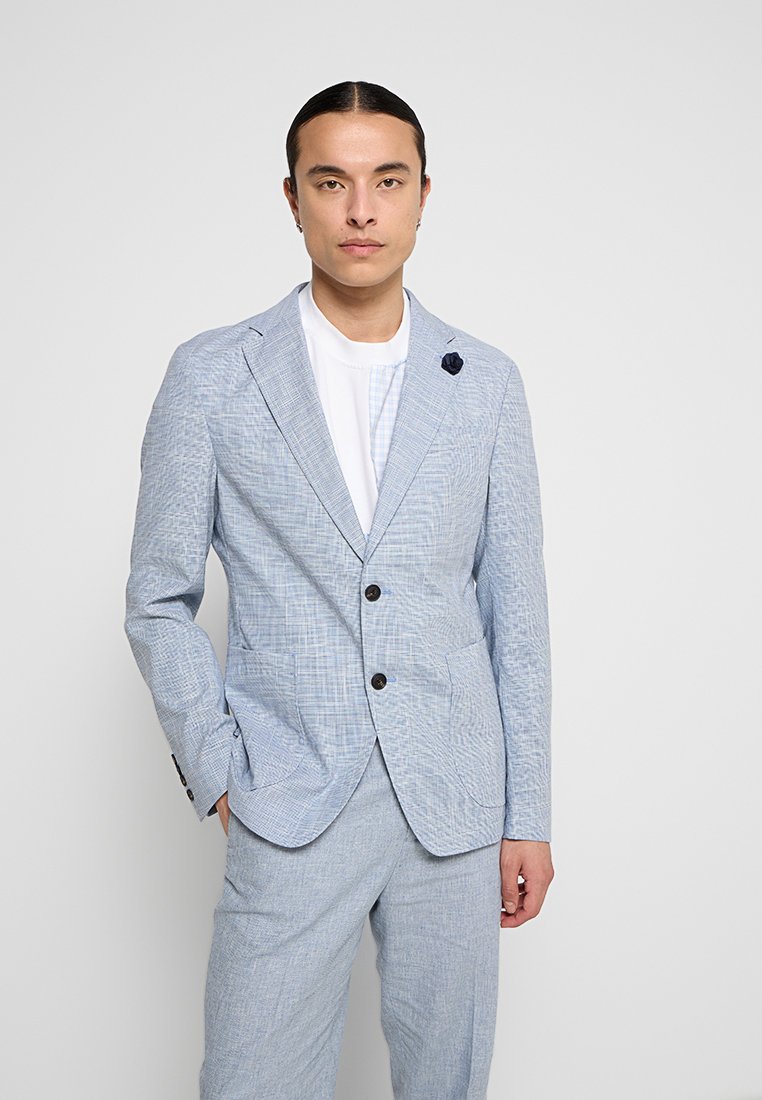 Giacca di suit strutturata azzurro chiaro con due bottoni, rever a rotondo e una spilla floreale. La giacca si abbina a pantaloni coordinati per un look armonioso.