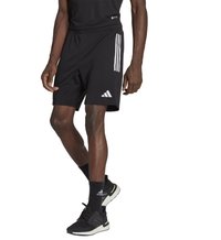 Zwarte sportshorts met drie witte strepen aan de zijkanten, elastische tailleband en een Adidas-logo, gedragen met zwarte sneakers en sokken.