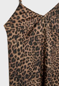 Débardeur à motif léopard avec une texture lisse semblable à celle du satin, doté de fines bretelles ajustables et d'un décolleté en V.