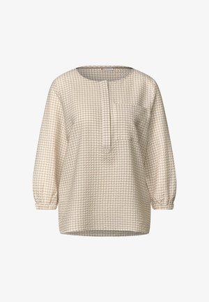 Top bianco con motivo a griglia color marrone chiaro, caratterizzato da un collo rotondo, maniche lunghe a sbuffo e una tasca frontale. Tessuto a rilievo.