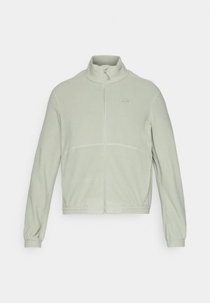 Fleecejacke in Hellgrün mit Stehkragen, durchgehendem Reißverschluss, elastischen Bündchen und dezenten Steppdetails über der Brust.