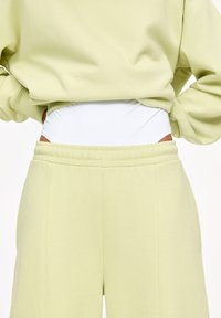 Helles grünes Loungewear-Set mit einem kuscheligen Sweatshirt mit gerippten Bündchen und passenden hochgeschnittenen Shorts mit einem weißen elastischen Bund.