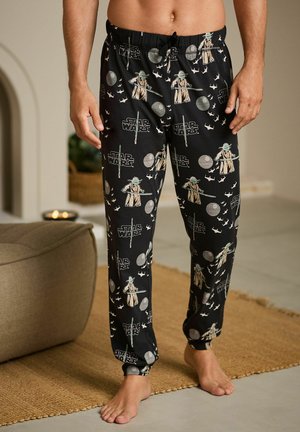 Pantaloni de pijama negri cu un design Star Wars, prezentând modele cu Yoda și nave spațiale. Făcuți dintr-un material moale, cu o talie elastică și glezne manșonate.