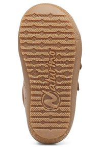 Hnědá podrážka boty s texturovaným gripem; obsahuje kulatou značku a název značky "Naturino" vyražený ve světlé barvě.