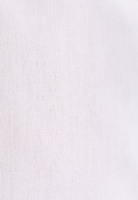 Tissu blanc texturé avec un petit motif tricoté uniformément espacé, montrant un matériau doux et des détails de tissage fins.