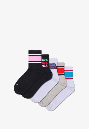 Čtyři páry podkolenek v černé, šedé, bílé a pastelových barvách; některé varianty mají pruhy a grafické textové loga.