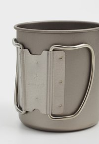 Tazza in acciaio inossidabile con finitura grigia opaca, dotata di manico in metallo argentato e logo impresso. Design elegante con forma arrotondata e superficie liscia.