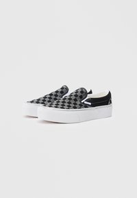 Fekete és szürke kockás slip-on cipők fehér gumitalppal. A felsőrész texturált anyagból készült, és sima fekete díszítéssel rendelkezik a saroknál.