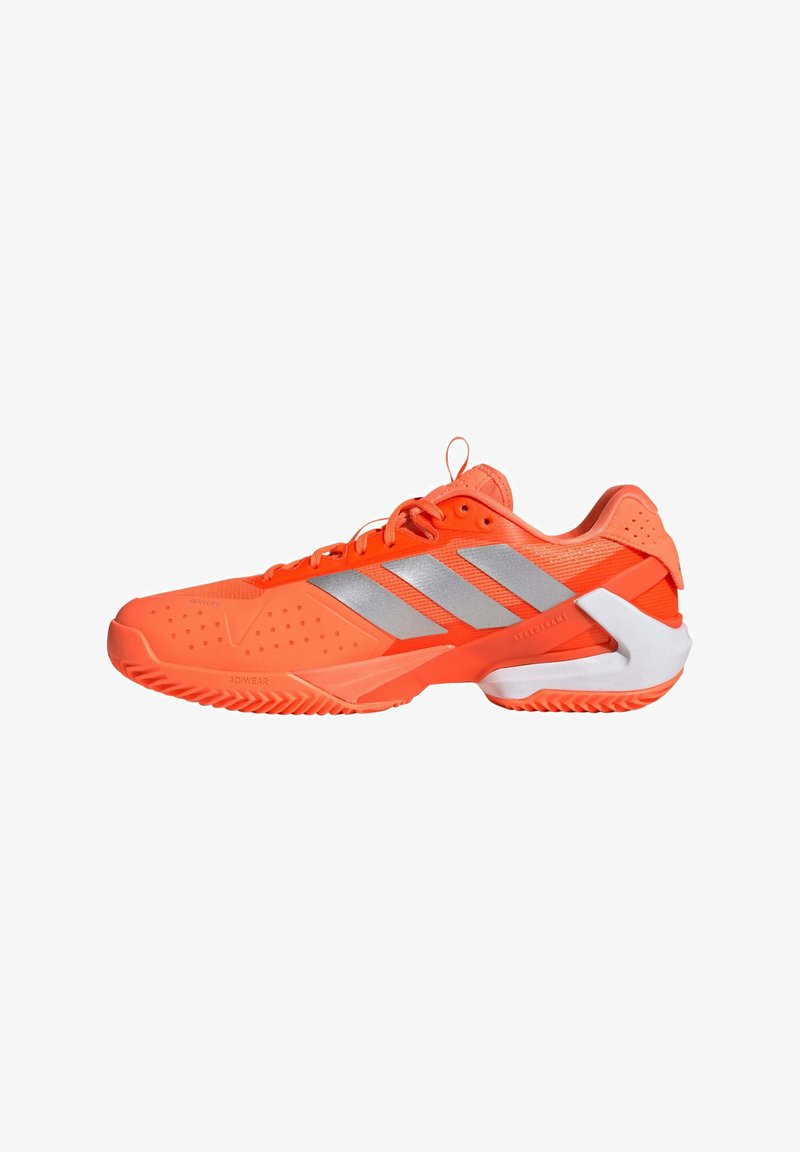 Chaussure de sport orange vif avec des bandes argentées, lacets à l'avant et talon blanc de soutien conçue pour une utilisation sportive.