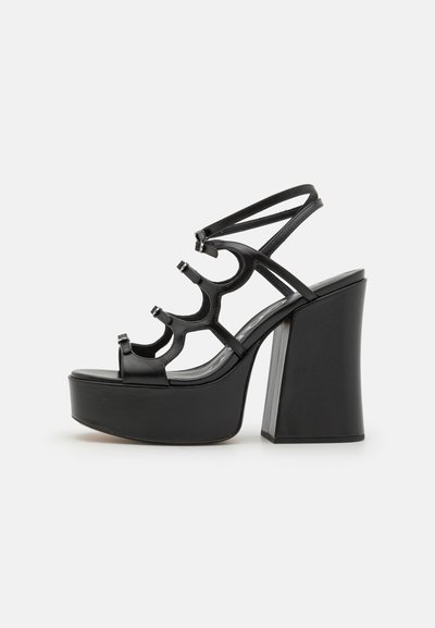 Sorte platform sandaler med en kraftig hæl, med en blank læderoverdel, udskæringsdesign og justerbare stropper.