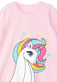 Rosa Kurzarmshirt mit einem Einhornmotiv, das eine mehrfarbige Mähne und Sterne zeigt. Weicher Stoff mit Rundhalsausschnitt und Druckdetails.