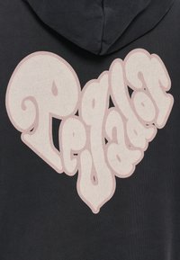 Zwarte hoodie met een groot hartvormig grafisch ontwerp in lichtroze, waarop het woord "Pejador" staat in een speelse, gebogen lettertype.