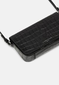 Sac bandoulière en cuir estampé crocodile noir avec une forme rectangulaire élégante, un rabat supérieur et une bandoulière réglable. Présente le logo de la marque à l'avant.