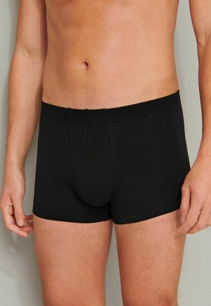 Schwarze Baumwollboxershorts mit enganliegendem Schnitt, ausgestattet mit einem verstärkten Frontbereich und einem elastischen Bund. Glatte Textur mit minimalen Nähten.