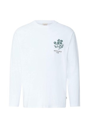 Chemise blanche à manches longues avec un motif floral vert et le texte "ARCHIVE of SOLID © 1999" sur le côté gauche de la poitrine.