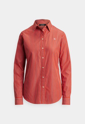 Červená košeľa na gombíky s vertikálnymi bielymi pruhmi, dlhými rukávmi a zaobleným lemom. Malé vyšívané logo na ľavej strane hrudníka.
