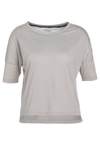 Camiseta atlética de manga corta en gris claro de Nike, que presenta un patrón texturizado, un cuello redondo y un logo reflectante en el pecho.