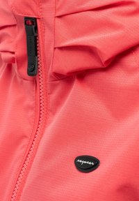Close-up of coral jacket fabric with visible zipper and black rubber logo reading "ragwear."