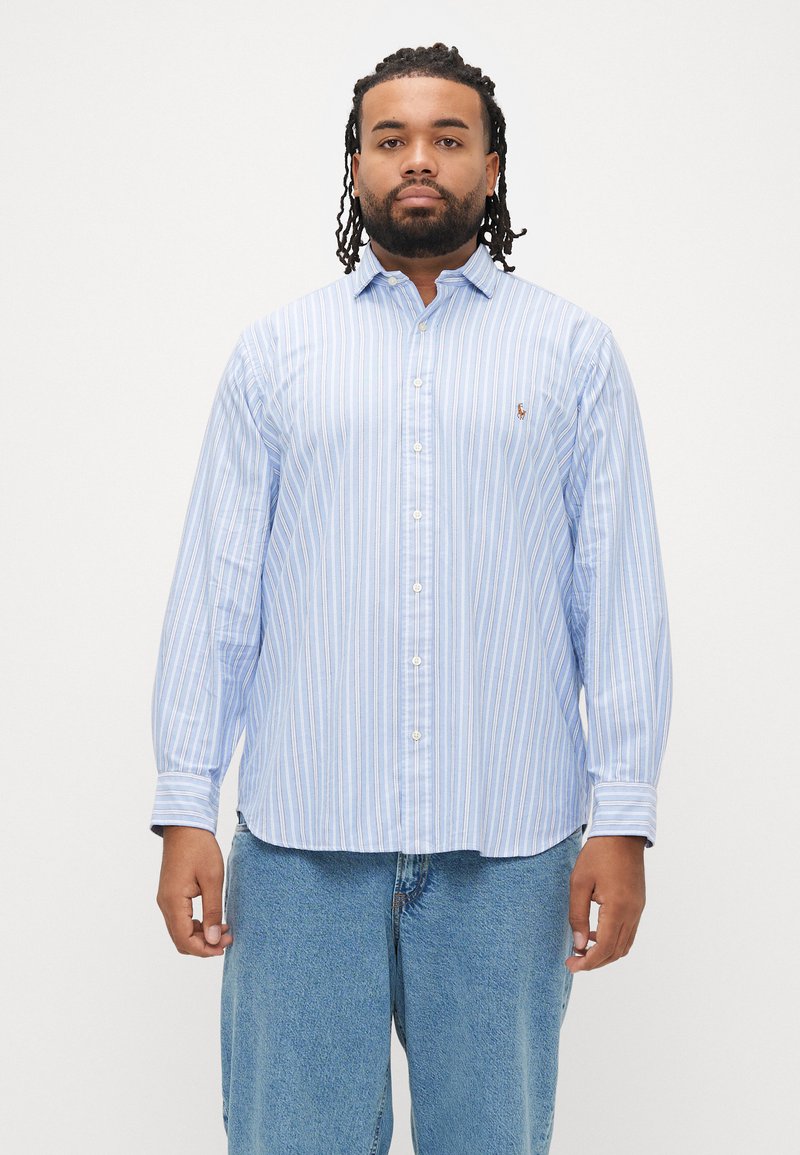 Camisa de botão azul claro às riscas, em mistura de algodão, com mangas compridas e gola clássica. Apresenta um pequeno logótipo bordado no peito.