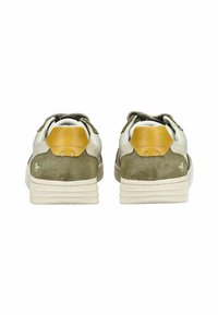 Sneaker da uomo con tomaia in suede verde oliva, dettagli in pelle crema e un tab sul tallone giallo, accompagnati da una suola in gomma bianca testurizzata.