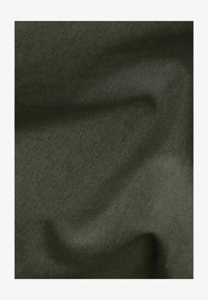 Donkergroene stof met fijne textuur en subtiele plooien die zachte schaduwen en highlights creëren.