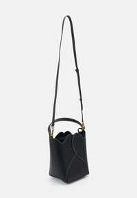 Czarna skórzana torba w kształcie wiadra z falbaniastym krawędzią, białymi przeszyciami i długim regulowanym paskiem. Złote akcenty z metalu.