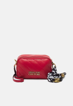 Rode gewatteerde handtas met gouden hardware, voorzien van het "Versace Jeans Couture" logo. Inclusief een zwart-wit gestippeld accent sjaal bevestigd.